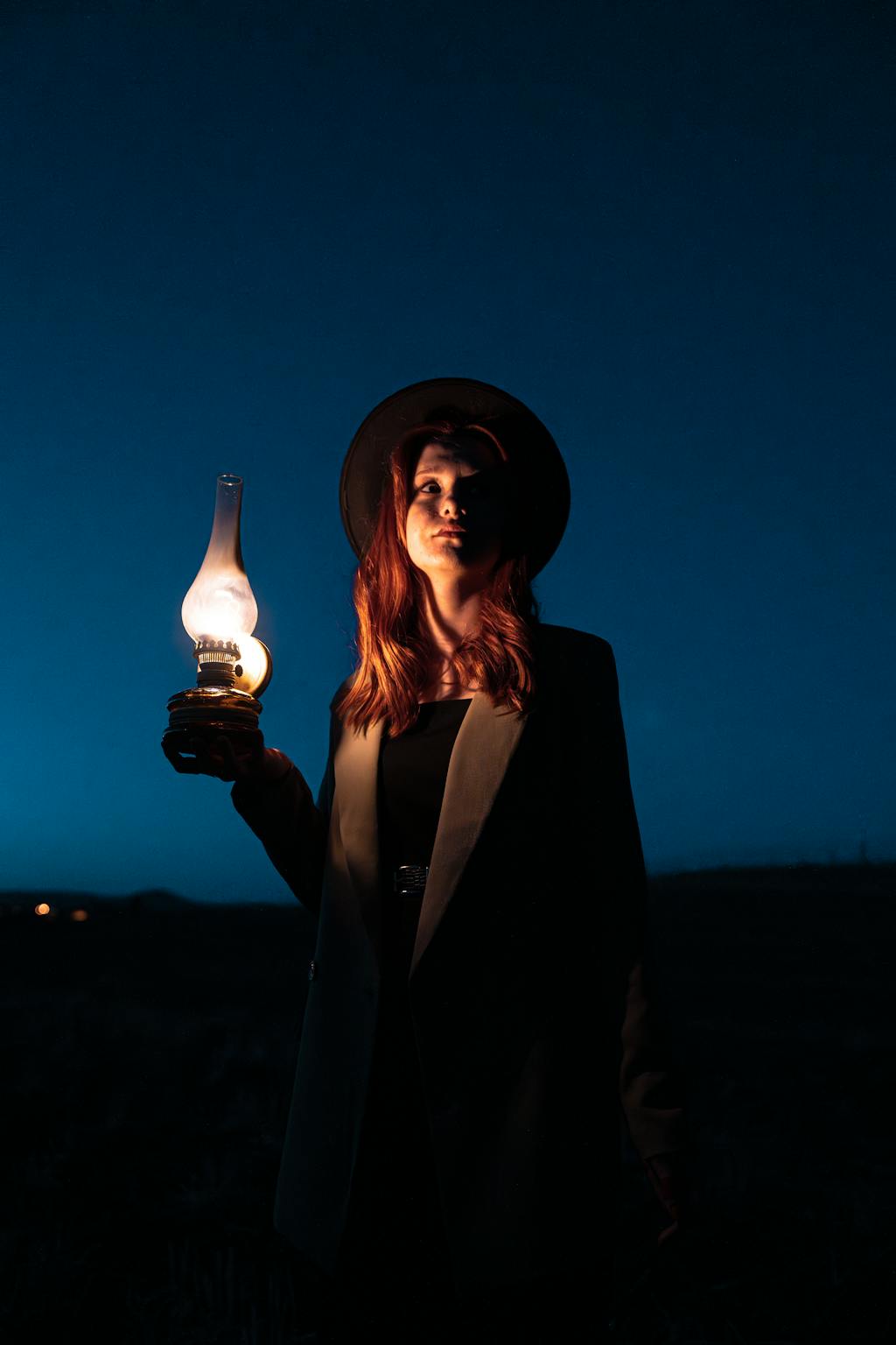 Accompagnement financier éclairé : une femme avance dans l’obscurité avec une lampe, symbole de conseil en épargne et investissement
