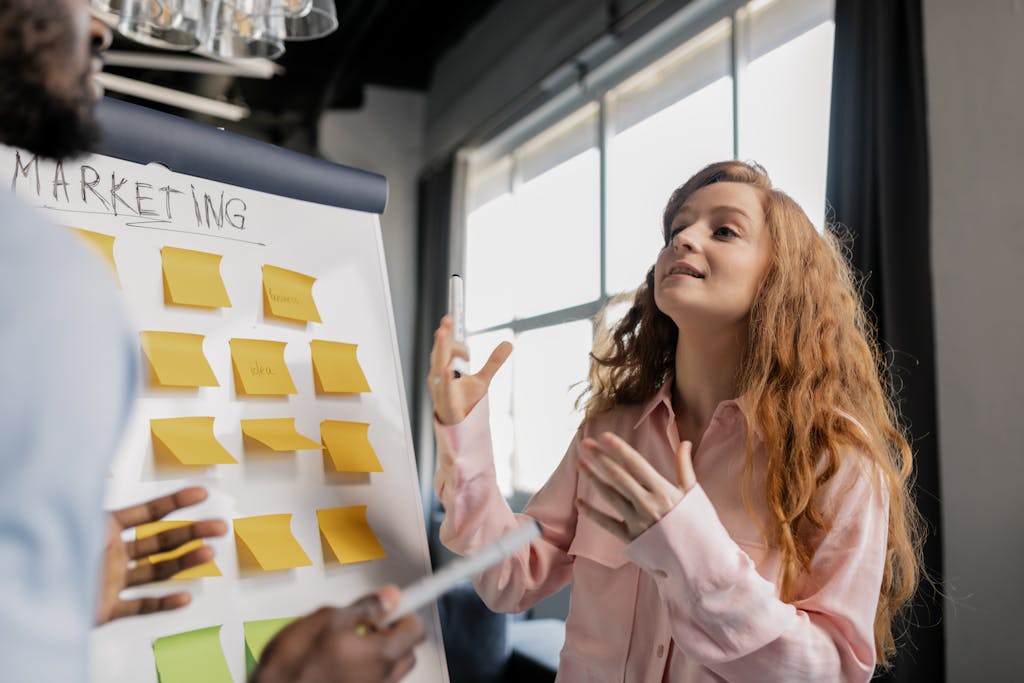 Femme souriante devant un tableau de critères en train d’expliquer comment choisir son contrat d’assurance vie